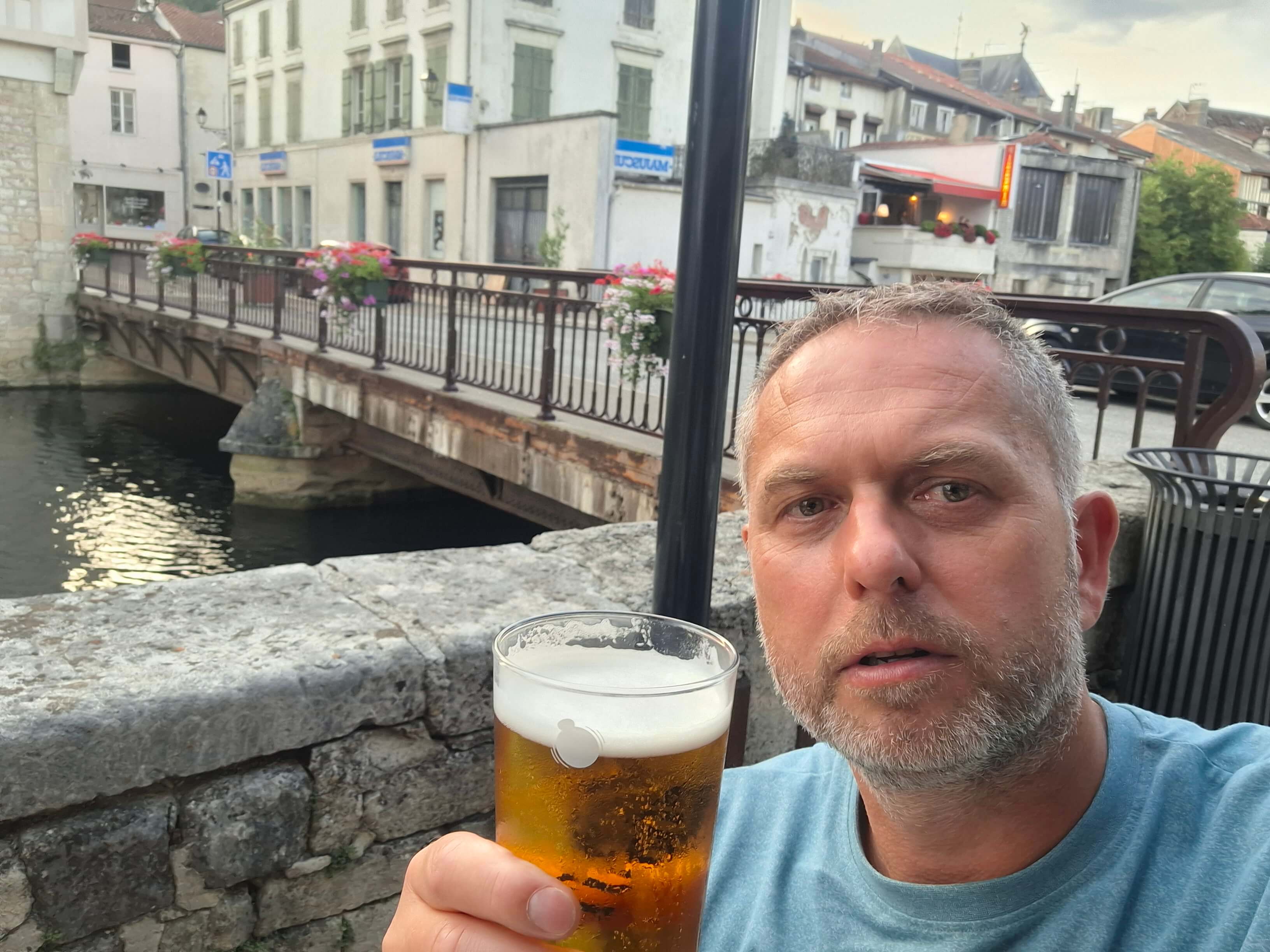 Danny with a pint, bridge and town behind