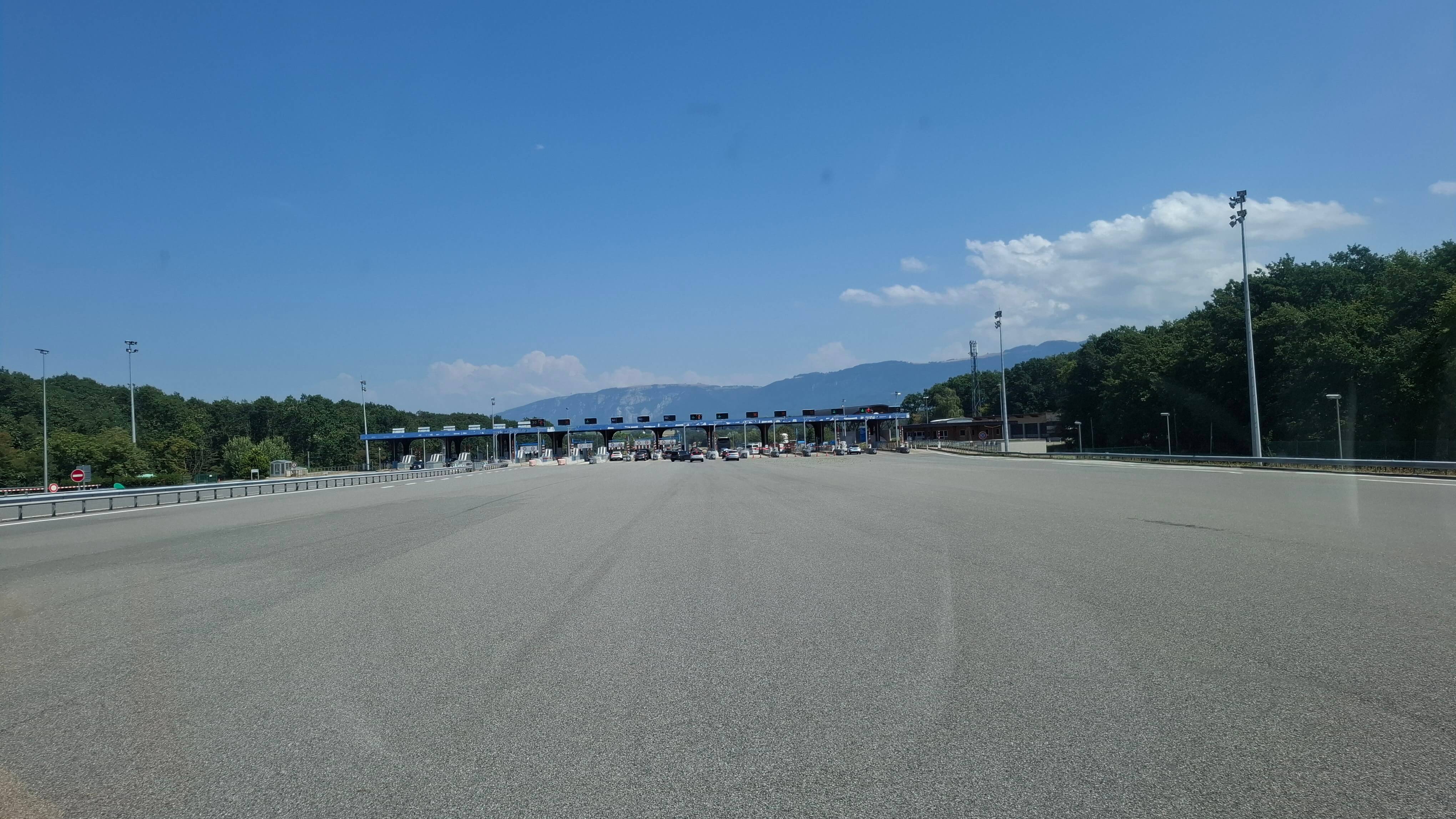 Toll booths with the Alps rising ahead